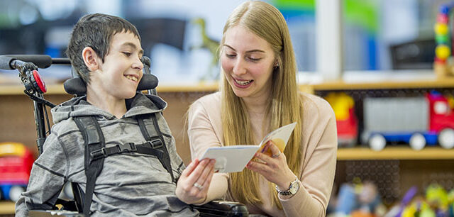 photo - Student in Wheelchair Being Read a Book