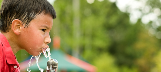 Boy Drinking From Water Fountain on Hot Day