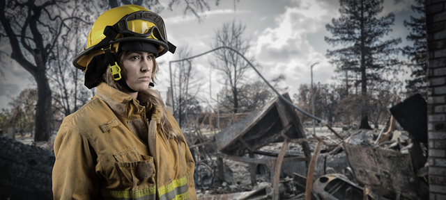 Photo of a female firefighter in a burned forest