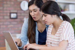 photo - Mother and daughter working together on laptop