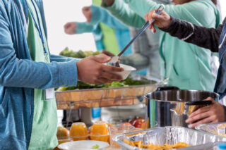 photo - volunteers serve food to those in need