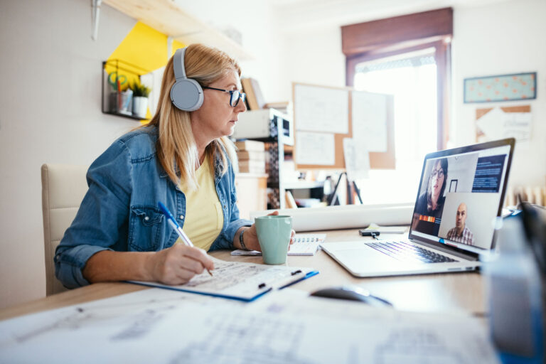 photo - Woman Wearing Headphones and on Zoom, Working in Her Home