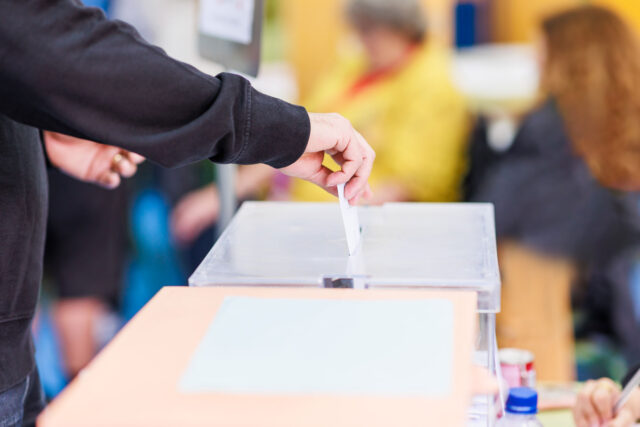 photo - Man's Hand Submitting Ballot