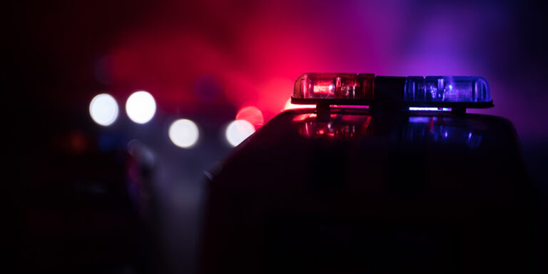 photo - Police Car Chasing a Car at Night