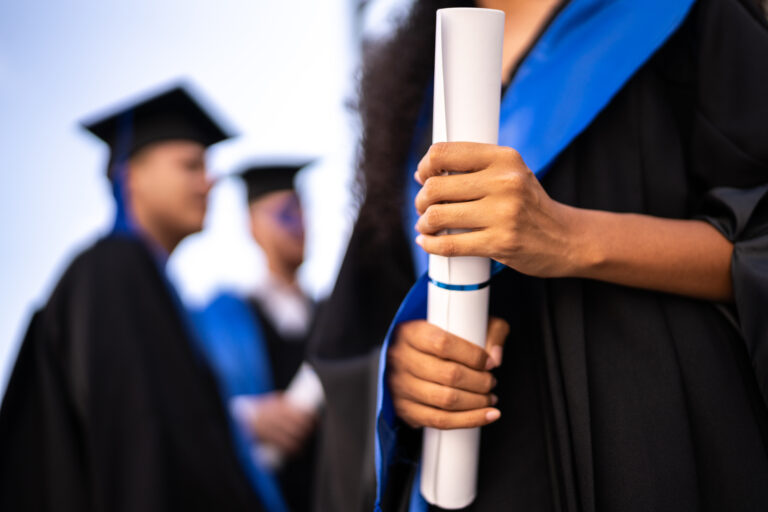 photo - Young Woman Holding a Diploma on Graduation